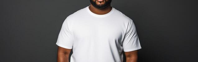 Confident man in plain white shirt poses against dark background photo
