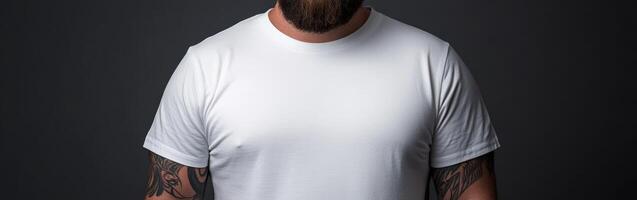 Tattoed man poses confidently in a white shirt against a dark backdrop photo