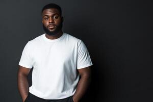 Young man poses confidently against a dark background in casual attire photo