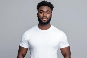 Young man poses confidently in a plain white t-shirt against a gray backdrop photo