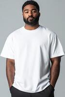 Man in plain white shirt stands confidently with hands in pockets photo
