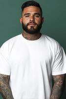 Strong man with tattoos poses against a solid green background photo