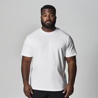 Man in plain white t-shirt stands confidently against light backdrop photo