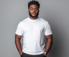 Young man poses confidently in a plain white t-shirt against a gray backdrop photo