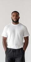 Stylish man poses confidently in casual white t-shirt against plain backdrop photo