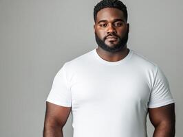 Confident man in a plain white t-shirt poses against a neutral background photo