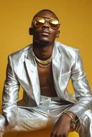 Stylish model poses in a silver suit against a yellow background photo