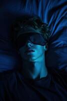 Individual resting in a dark room while wearing a sleep mask and relaxing photo