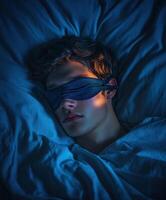 Sleeping teenager with eye mask resting in dimly lit bedroom photo