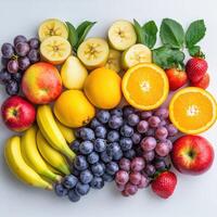 Fresh assorted fruits arranged beautifully on a light background photo