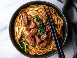 Savory beef stir-fry noodles with fresh greens in a bowl photo