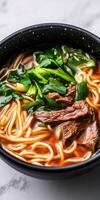 Savoring a bowl of steaming beef noodle soup with fresh greens photo