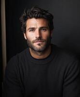 Handsome man with dark hair and beard wearing a black sweater photo