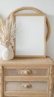 Stylish home decor with a blank frame and natural elements on a dresser photo