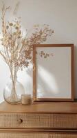 Elegant decor arrangement featuring dried flowers and a blank frame photo