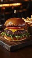 Juicy cheeseburger served with golden fries on a rustic wooden board photo