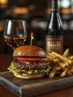 Gourmet burger with cheese and fries paired with wine on rustic table photo