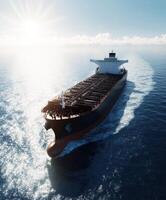 Massive cargo ship navigates open waters under bright sunlight photo