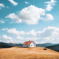 House in a vast field under a bright blue sky with fluffy clouds photo
