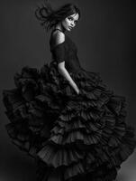 Elegant model in dramatic black gown with flowing ruffles photo