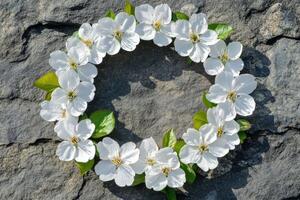 White flower wreath on a textured stone surface in natural light photo