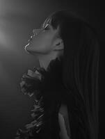 Elegant portrait of a woman in profile against a dark background photo