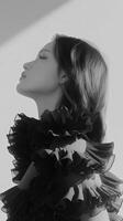 Elegant woman in ruffled black attire captured in soft light photo