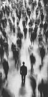 Crowd in motion with a lone figure standing still in a busy urban environment photo