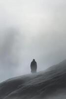 Solitary figure on a foggy mountain at dawn during winter photo