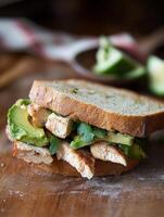 Delicious chicken and avocado sandwich served on whole grain bread photo