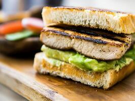 Grilled chicken sandwich with avocado served on wooden board photo