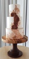 Elegant floral three-tier cake on wooden stand at a celebration photo