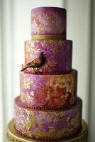 Elegant four-tier cake decorated with intricate patterns and a bird figure photo