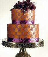 Elegant two-tiered cake adorned with grapes and intricate design photo
