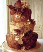 Elegant three-tier wedding cake adorned with chocolate flowers and details photo