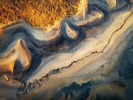 Natural patterns formed by winding river at sunset near a coastal area photo