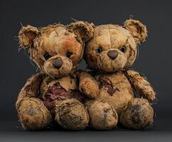 Worn teddy bears sitting closely together showing signs of age and love photo