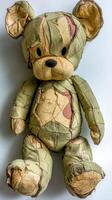 Unique teddy bear covered in patchwork fabric with a worn appearance photo