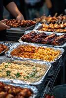 Assorted grilled meats and pasta at a food festival in the evening photo