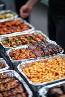 Grilled meats and sides displayed at an outdoor food event photo