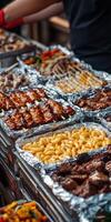 Delicious grilled meats and sides displayed at outdoor food market event photo