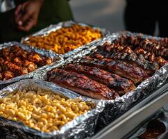 Grilled meats and sides prepared for a summer barbecue gathering outdoors photo