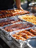 Delicious barbecue spread featuring various meats and sides at outdoor gathering photo