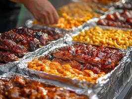 Barbecue feast with various meats and sides at outdoor event in sunny weather photo