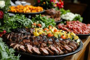 Sliced beef tenderloin with grilled vegetables and various dishes displayed on a buffet table photo
