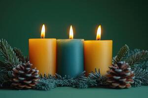 Three burning candles with pine cones and spruce branches creating a festive atmosphere photo