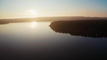 Beautiful view of a sunset on a river. Cinematic footage on the evening river. Sun setting in nature. Aerial view. video