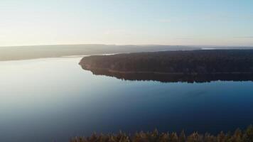 Beautiful view of nature. Wide river with blue calm water in the evening. Small island surrounded by water. Aerial view. video