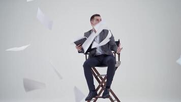 Businessman in a chair shouting. Many papers are flying in the studio and a man in suit with opened mouth. Slow motion. video