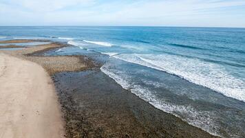 Coastal view of Trestles in San Clemente showcasing serene beach and gentle ocean waves under a clear sky photo